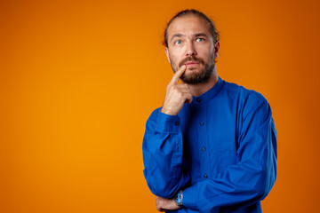 Confused bearded young man thinking about something