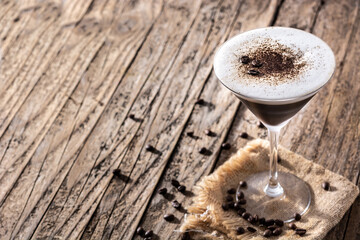 Martini espresso cocktail in glass on wooden table. Copy space