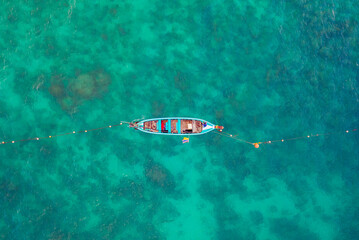 Aerial View of Thai traditional longtail fishing boats in the tropical sea in phuket thailand