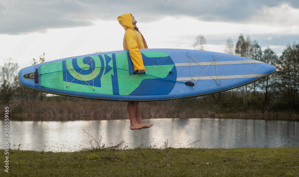 Wall mural surfer with a Board in cloudy weather, dynamic photography,