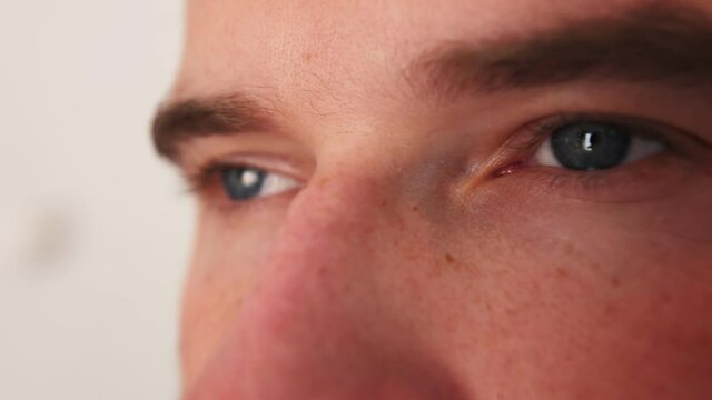 Eyes of an caucasian man. closeup view of a person's face. The man is looking at the camera. The man's gaze looks ahead.