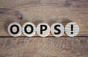 Oops sign on wooden circles. Beautiful wooden background, copy space. Business concept.