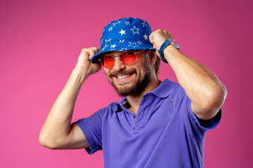 Funny bearded smiley man wearing beach hat and sunglasses