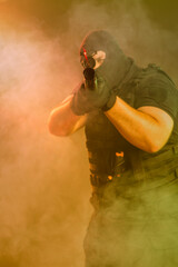 Soldier comes out of the smoke on the battlefield. The concept of military special operations. Aim...