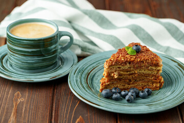 Piece of honey cake with nuts on green plate