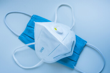 Respirator with exhalation valve and medical protective masks on a blue background