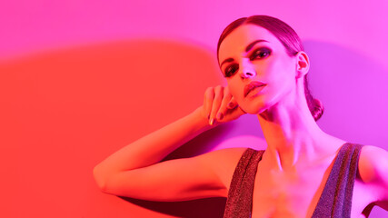 Woman in colorful neon light, make-up. Sexy Fashion girl, stylish hair, trendy makeup. Party disco neon style. Creative art beauty portrait, fashionable model, bright make up