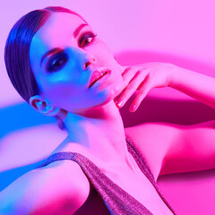Woman in colorful neon light, make-up. Sexy Fashion girl, stylish hair, trendy makeup. Party disco neon style. Creative art beauty portrait, fashionable model, bright make up