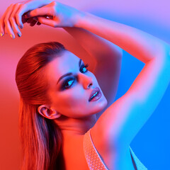 Woman in colorful neon light, Fashion make-up. Sexy girl, stylish hair, trendy makeup. Party disco style. Creative art beauty portrait, fashionable model, bright make up
