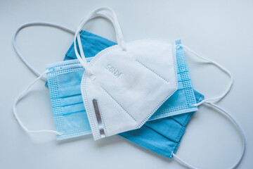 Respirator with exhalation valve and medical protective masks on a blue background