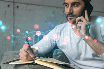 Handsome manager in casual wears, speaking phone, taking notes at office try to solve IT challenge from client. Double exposure. The concept of abstract technology.