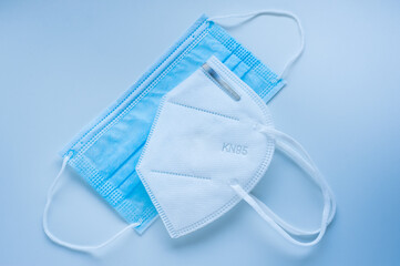 Respirator with exhalation valve and medical protective masks on a blue background