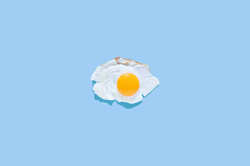 Fried eggs on a light blue background. Minimalism, top view. Breakfast concept, fried food.