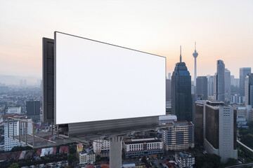 Blank white road billboard with Kuala Lumpur cityscape background at sunset. Street advertising poster, mock up, 3D rendering. Side view. The concept of marketing communication to promote or sell idea