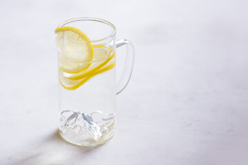 three lemons on a gray background. half a lemon, mint leaves. Lots of space, dark background 
