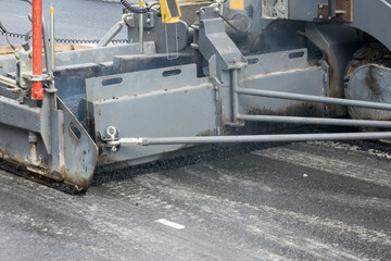 Close up asphalt laying machine. Asphalt paver. Tarmac road laying machine. Asphalt spreader. Road construction