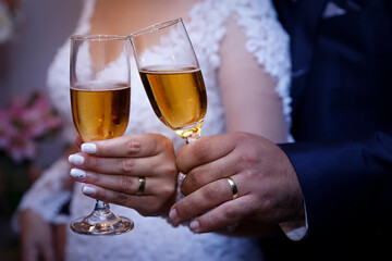 hands of wedding couple with wedding rings toasting bowls