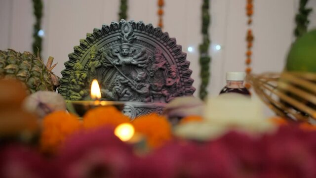 Closeup shot of a beautifully decorated platform with Goddess Durga's idol. A colorful temple/puja Ghar of Ma Durga decorated with Diyas  fruits  and flowers for Durga Puja festival