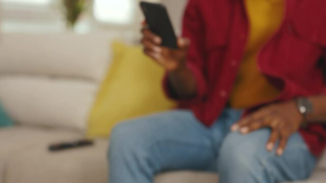 Portrait serious young african american man use phone sit on sofa in home. Communication in social media online relax work app. Handsome focesed guy. Internet. Portrait. Slow motion