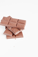 Milk chocolate pieces isolated on white background from top view, close up a chocolate bar isolated on white background