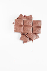 Milk chocolate pieces isolated on white background from top view, close up a chocolate bar isolated on white background