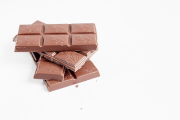 Milk chocolate pieces isolated on white background from top view, close up a chocolate bar isolated on white background
