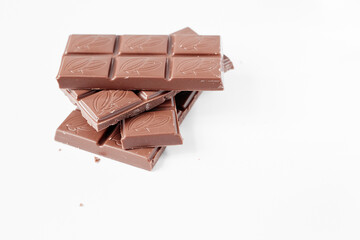 Milk chocolate pieces isolated on white background from top view, close up a chocolate bar isolated on white background