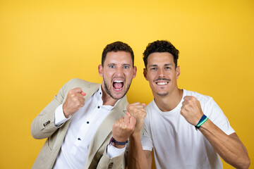 Young gay couple of two men wearing casual clothes over isolated yellow background very happy and...