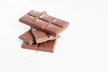 Milk chocolate pieces isolated on white background from top view, close up a chocolate bar isolated on white background
