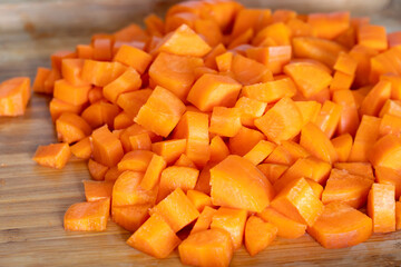 Diced carrots on wooden chopping board, food