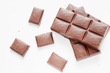 Milk chocolate pieces isolated on white background from top view, close up a chocolate bar isolated on white background