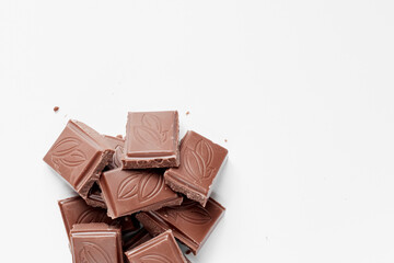 Milk chocolate pieces isolated on white background from top view, close up a chocolate bar isolated on white background