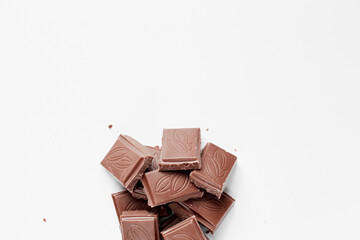 Milk chocolate pieces isolated on white background from top view, close up a chocolate bar isolated on white background