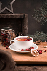 White tea Cup with lemon and berries on Christmas background. Side view. The concept of New year and Christmas.
