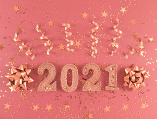 Greeting card of New Year 2021. Glittered figures, stars, bows and ribbons on a light pink background.