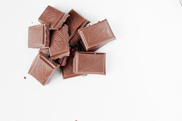 Milk chocolate pieces isolated on white background from top view, close up a chocolate bar isolated on white background