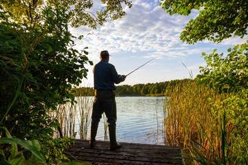 fisherman catching the fish from wooden pier 