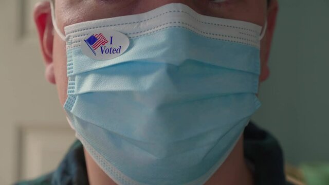 Man Puts I Voted Sticker On His Face Mask After He Votes During Pandemic