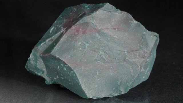 Mineral heliotrope on a black background. Bloodstone. A nugget of close-up vision.