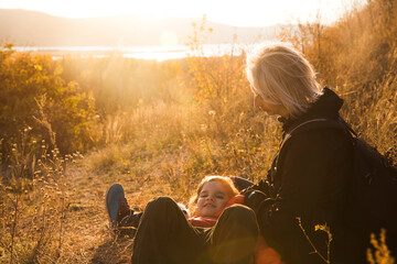 happy family Mom and the little daughter hug and play in autumn outdoor at sunset. family time together.  Stay cations, hyper-local travel,  family outing, 