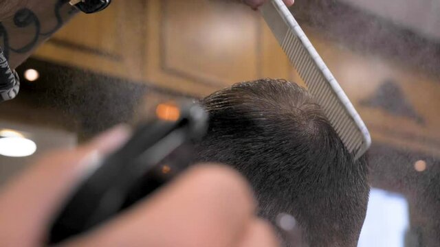 cinematic shot of the barber spraying some water