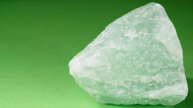 The stone is an aventurine close-up. A nugget on a green background.