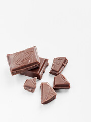 Milk chocolate pieces isolated on white background from top view, close up a chocolate bar isolated on white background