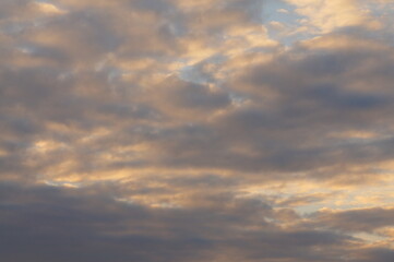 Clouds in the blue sky in the evening, during autumn, warm colours - background.