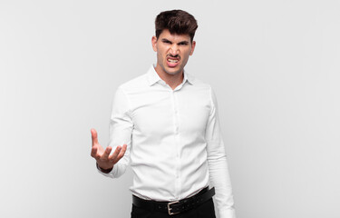 young handsome man looking angry, annoyed and frustrated screaming wtf or what’s wrong with you