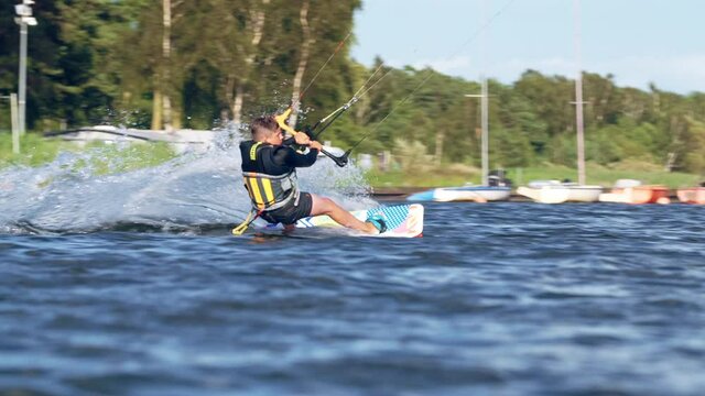 Young kiter catching wind with his kite. Windy day on a coast. Making tricks