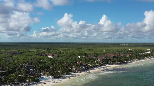 Espectacular vista a&eacute;rea panor&aacute;mica de Tulum Beach y los hoteles boutique de la zona, con un cielo azul y muchas nubes como fondo.