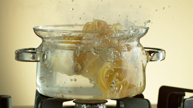 Super Slow Motion Shot of Fresh Pappardelle Falling into Boiling Salted Water at 1000 fps.