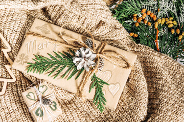 Christmas presents with gift box decorated with pine cones and twigs on on a cotton fabric  background, preparation for holidays. Christmas presents and New Year. Handmade. Selective focus,