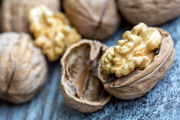Ripe and raw whole big walnut kernel with thin shell on wooden rustic backdrop. Healthy nut food for brain. Fresh walnuts background concept